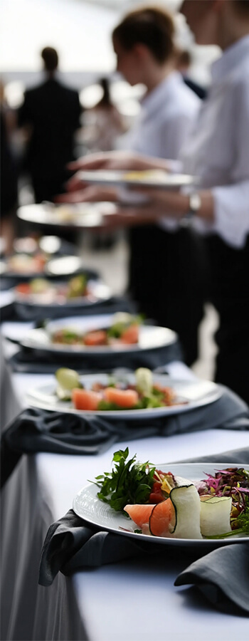 Catering staff serving elegant plated appetizers at a formal event.